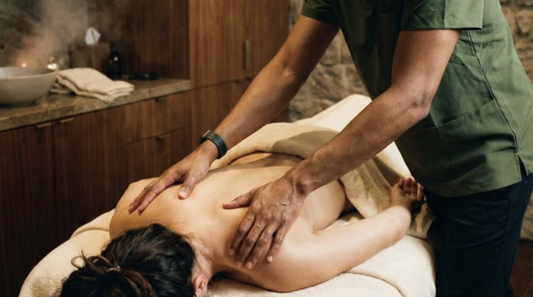 Jonathan Harper, licensed massage therapist, performing a back massage